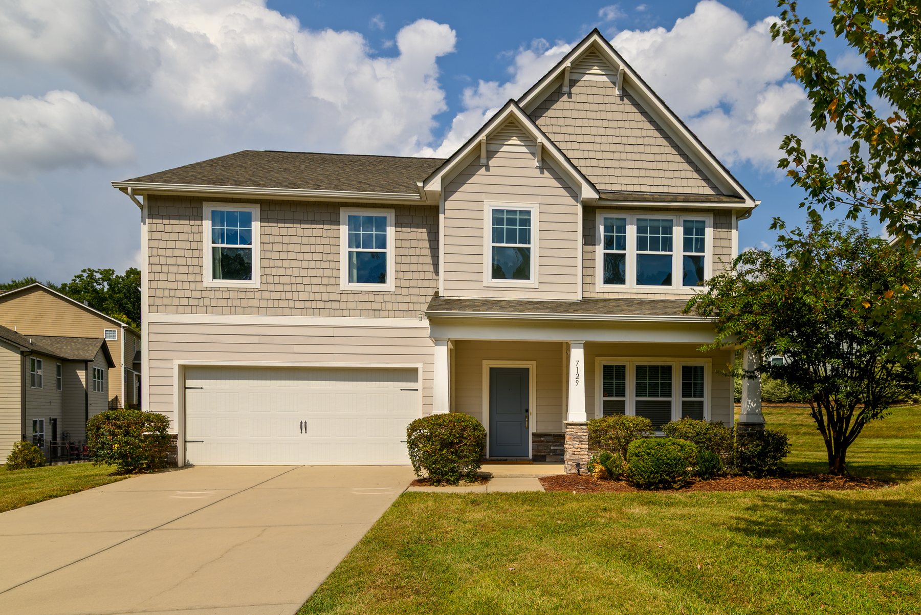 Front exterior of 7129 Dove Field Ln, Fort Mill, SC — a two-story home with a covered front porch and two-car garage